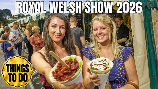 Two visitors enjoying Welsh food at the Royal Welsh Show 2026, with a Things to Do guide badge