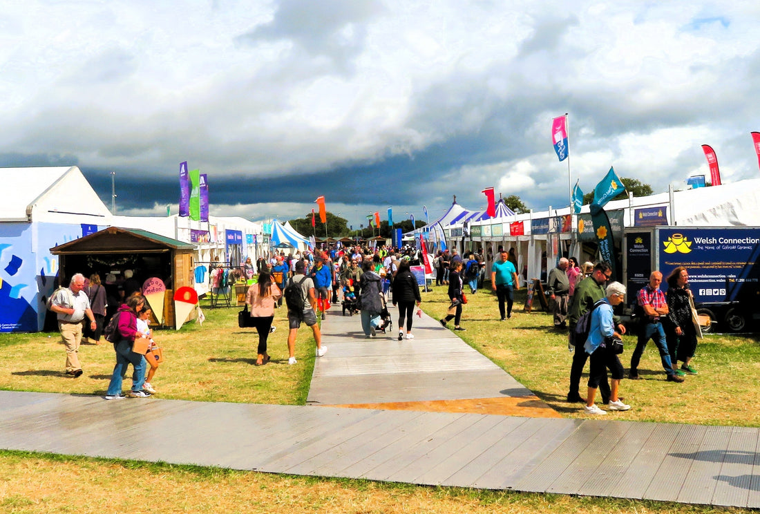 Colourful stalls and temporary units lining the Maes at the 2025 National Eisteddfod in Wrexham. Photo by Llywelyn2000, licensed CC BY 4.0, via Wikimedia Commons.