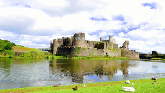 Caerphilly Castle reflected in its moat on a sunny day