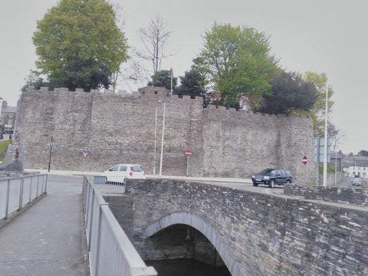 Cardigan Castle south wall and towers beneath a blue sky