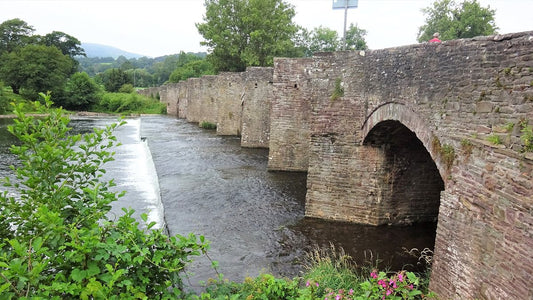 Crickhowell Bridge crossing the River Usk with wooded hills beyond