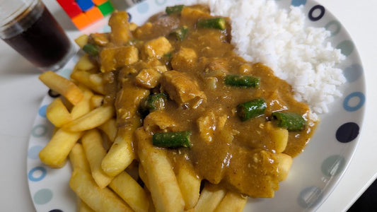 A plate of chicken curry served with both chips and white rice
