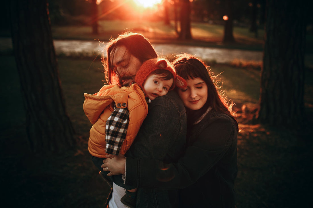 Family members sharing a warm outdoor embrace at sunset