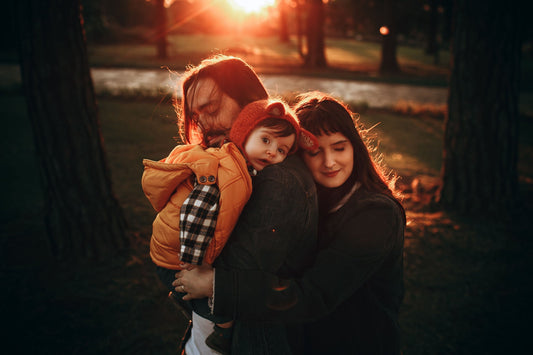 Family members sharing a warm outdoor embrace at sunset