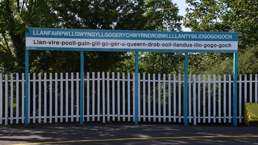 Long Welsh place-name sign at Llanfairpwll railway station on Anglesey.