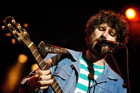 Gruff Rhys of Super Furry Animals singing and playing guitar on stage