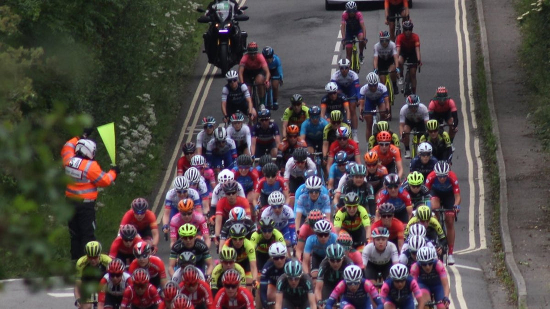 Women's Tour peloton riding along a tree-lined road