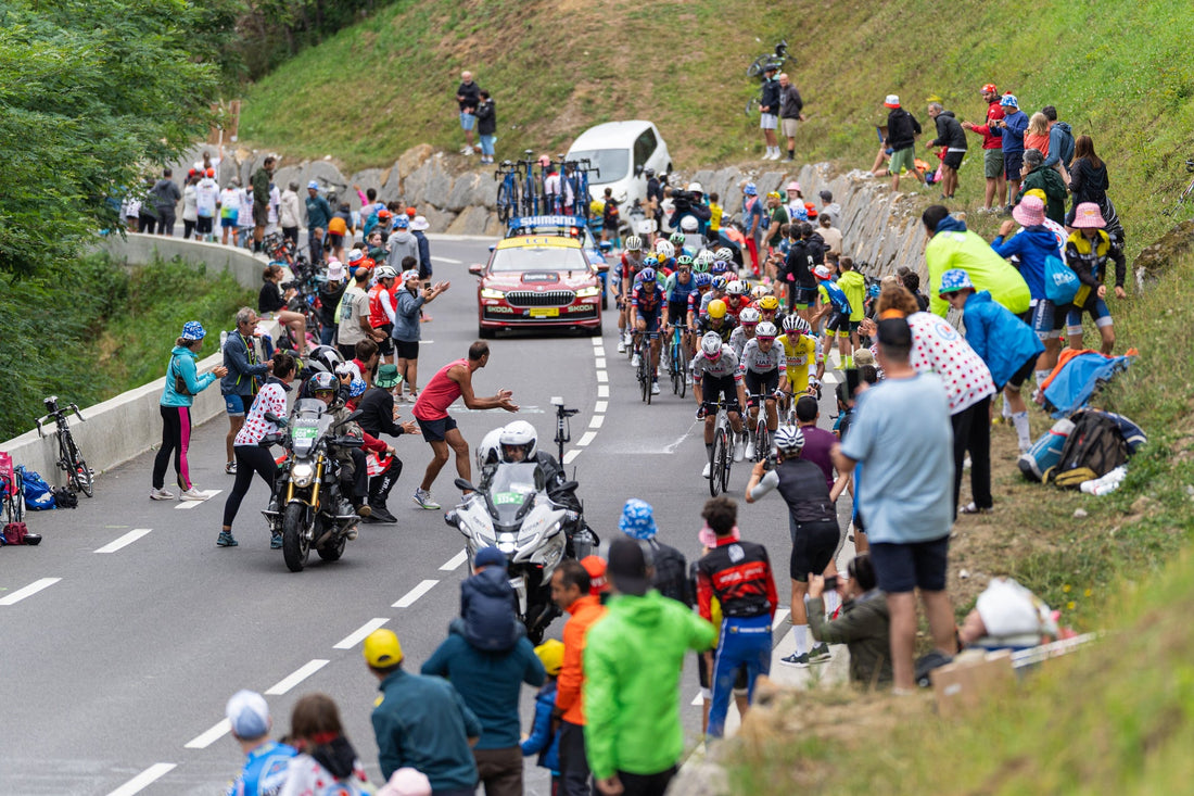 Tour de France peloton climbing between roadside spectators in the Pyrenees