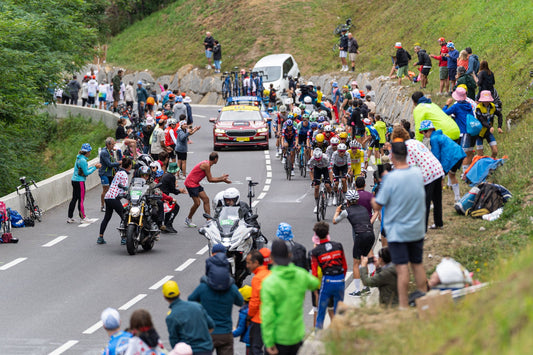 Tour de France peloton climbing between roadside spectators in the Pyrenees