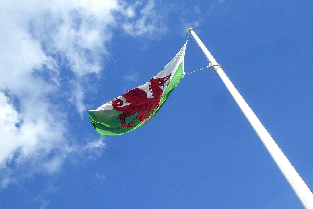 The red dragon flag of Wales flying above a stone tower at Raglan Castle in Monmouthshire
