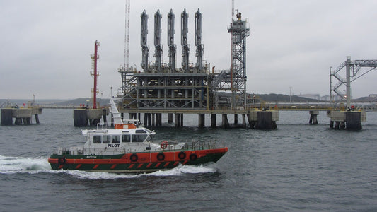 Pilot boat passing an oil jetty at Milford Haven
