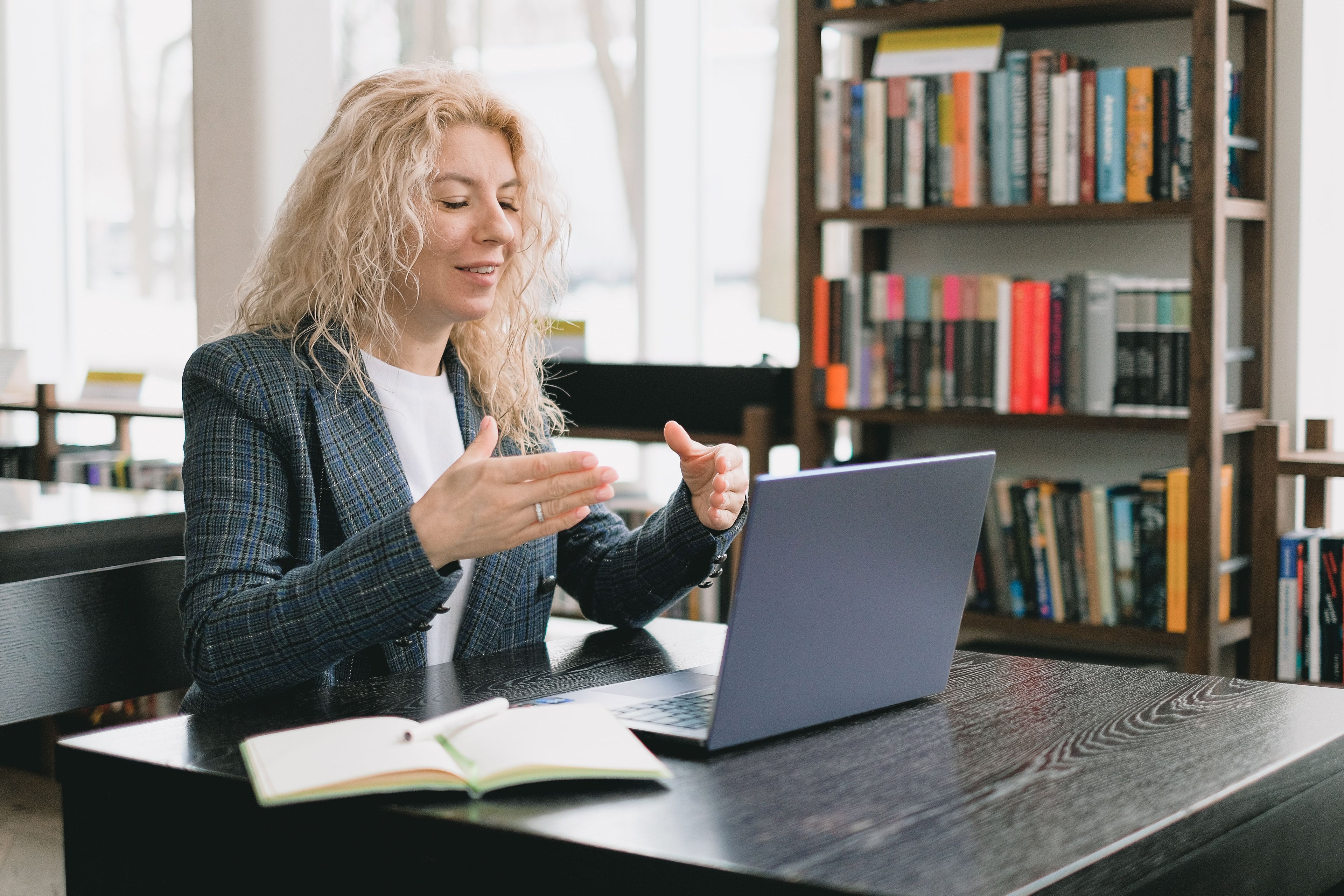 A woman speaking during an online video lesson from a library.